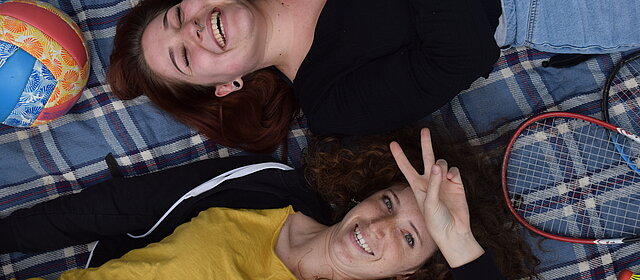 2023_ESK_Angebot zwei junge Menschen liegen lachend auf dem Boden